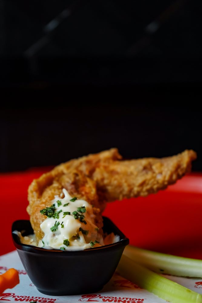 Alita de pollo con salsa ranch de la casa de Revolution Wings